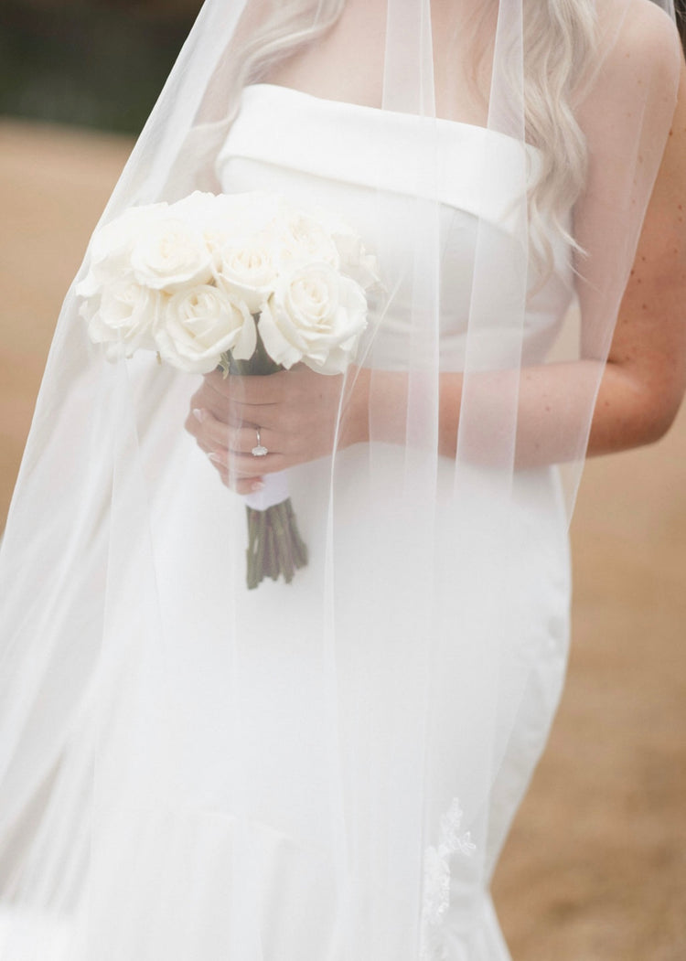 Bride holding a white garden rose bouquet under her veil