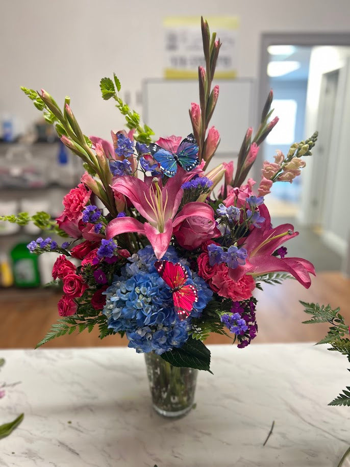Three red and white vase arrangements with roses, lilies, and hydrangea