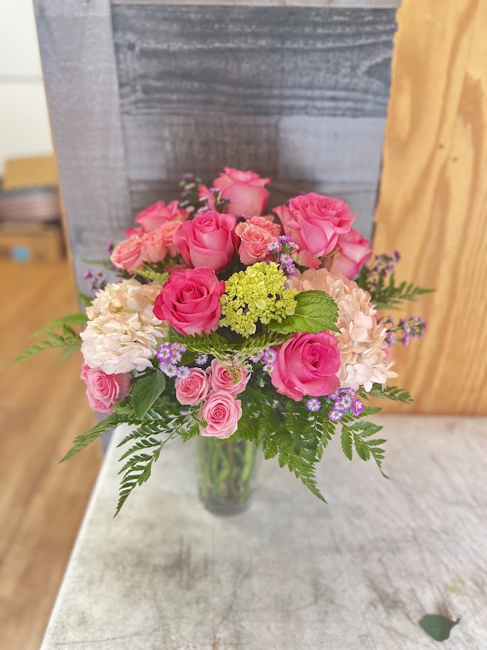 Pink lilies, blue hydrangea, and red roses with butterfly accents