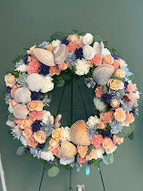 Wreath of peach and coral flowers accented with seashells